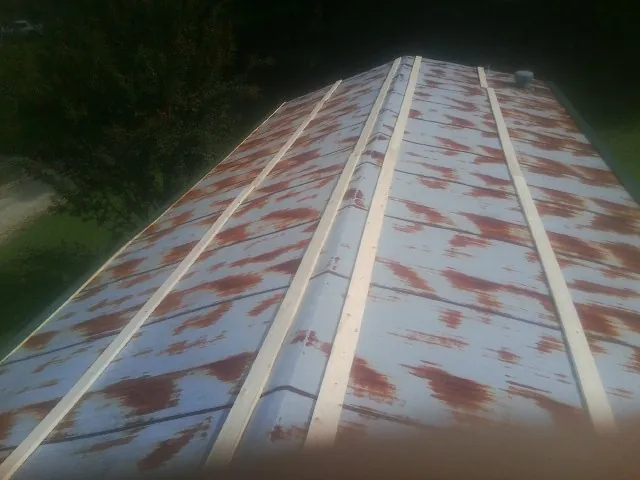 Rusted metal roof panels with new wood purlins before replacement — Storm Damage Roof Repair in Urbanna by Roofing Brothers