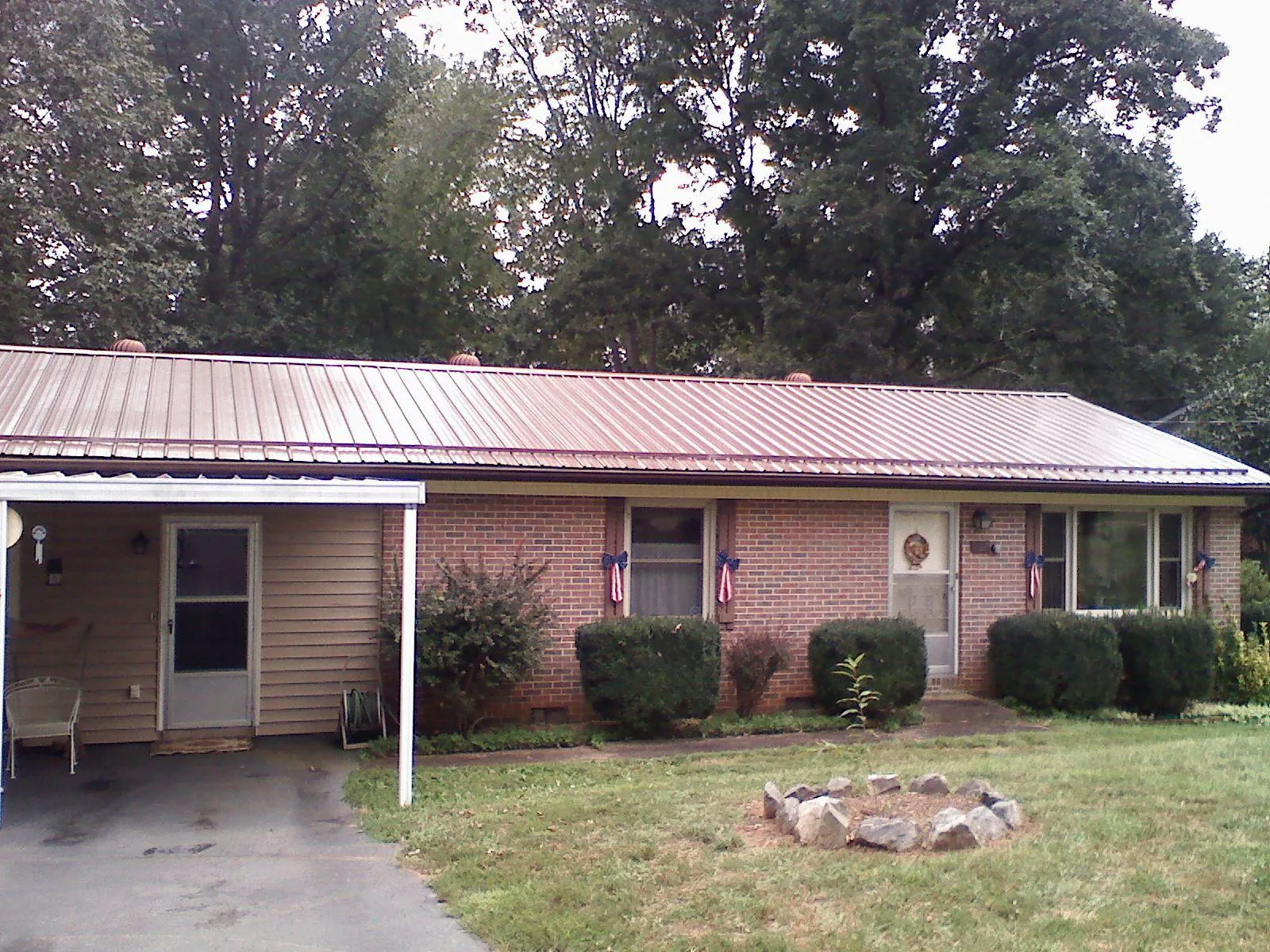 Bronze metal roof and carport on a brick ranch home — Roof Repair work by our crew in Urbanna