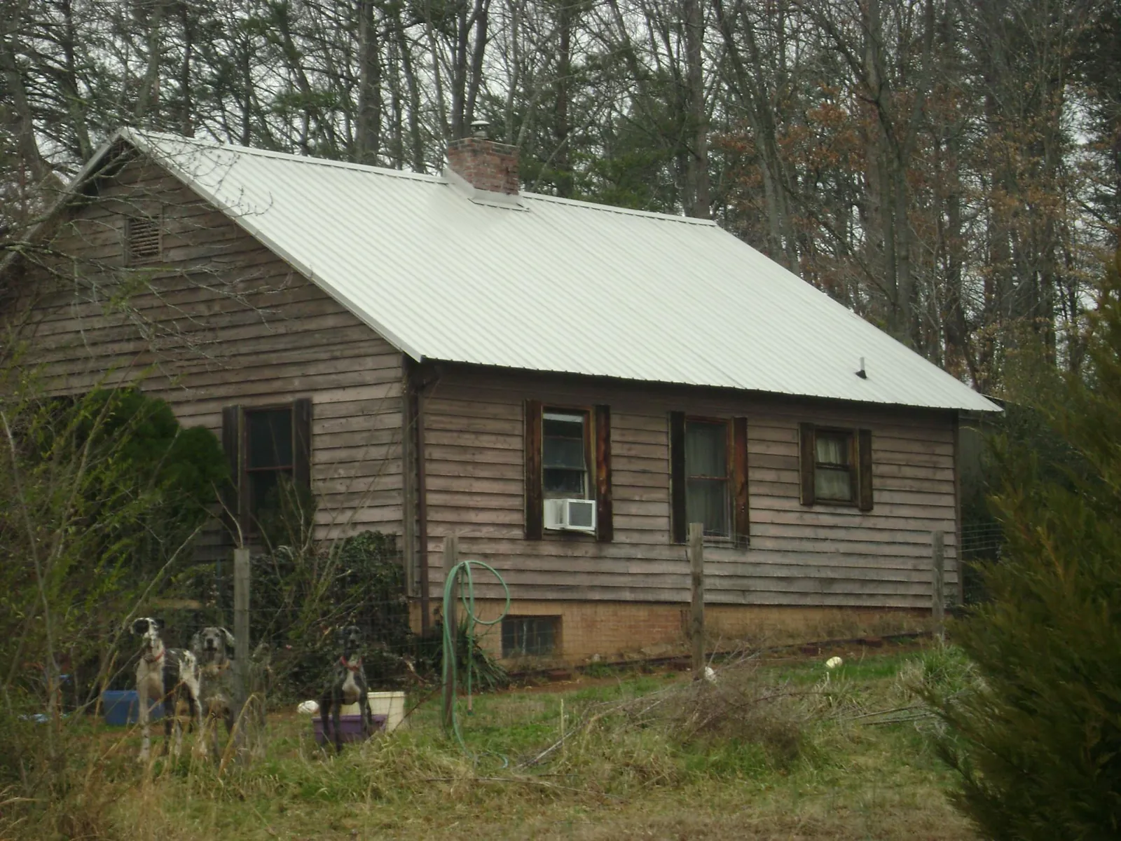 White metal roof on an old wood sided farmhouse, from a Metal Roof Installation job in Urbanna
